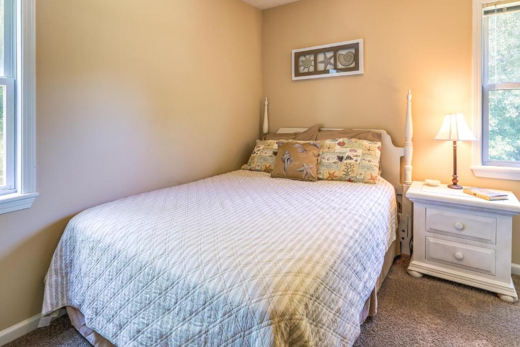 a bedroom with a bed and a nightstand at Charming Emerald Isle Escape Less Than 1 Mi to Beach! in Emerald Isle