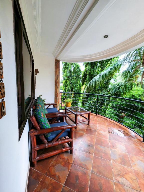 a room with a balcony with chairs and a table at Luxor garden 1 bedroom Apartment 3A in Accra