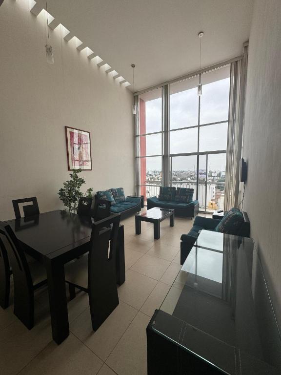 a living room with couches and a table and chairs at Amplio departamento con balcon in San Luis Potosí
