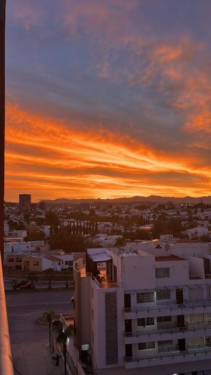 a sunset view of a city with a building at Amplio departamento con balcon in San Luis Potosí