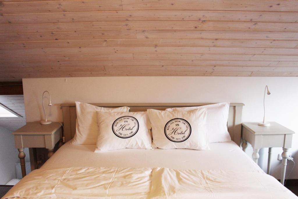 een bed met twee klokken op de kussens bij Casas Confort in Boží Dar