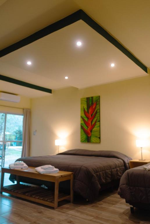 um quarto com uma cama e uma pintura na parede em Hostería Jasy em Colonia Carlos Pellegrini