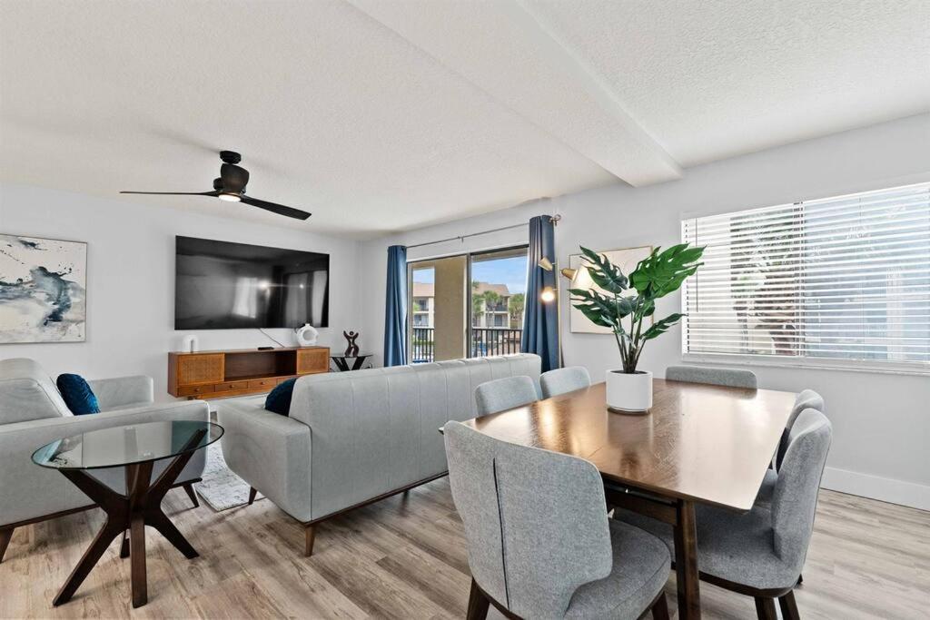 a living room with a table and chairs and a couch at Beachfront resort Heated Pool 3King beds 85in TV BBQ in Saint Augustine Beach