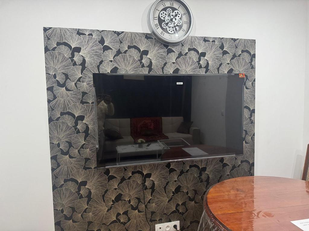 a living room with a tv on a wall at Appartement 10 min de stade de France et 15 min de airport CDG in La Courneuve