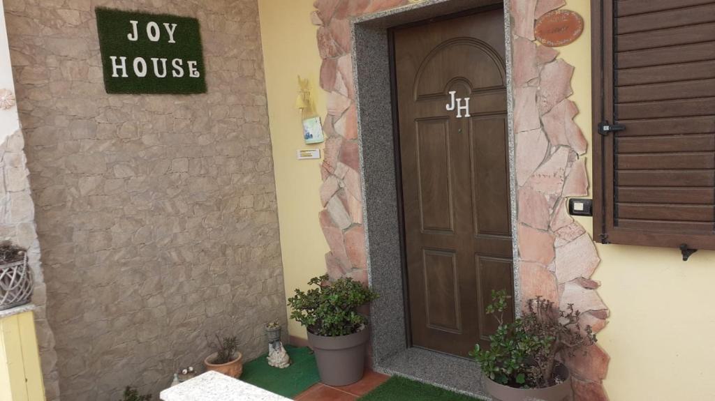 una puerta a una casa de la alegría con dos macetas en Joy House, en Porto Torres