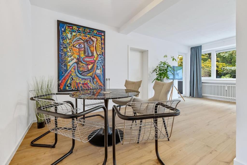 a room with a table and chairs and a painting at Cityperle - im Herzen Augsburgs in Augsburg