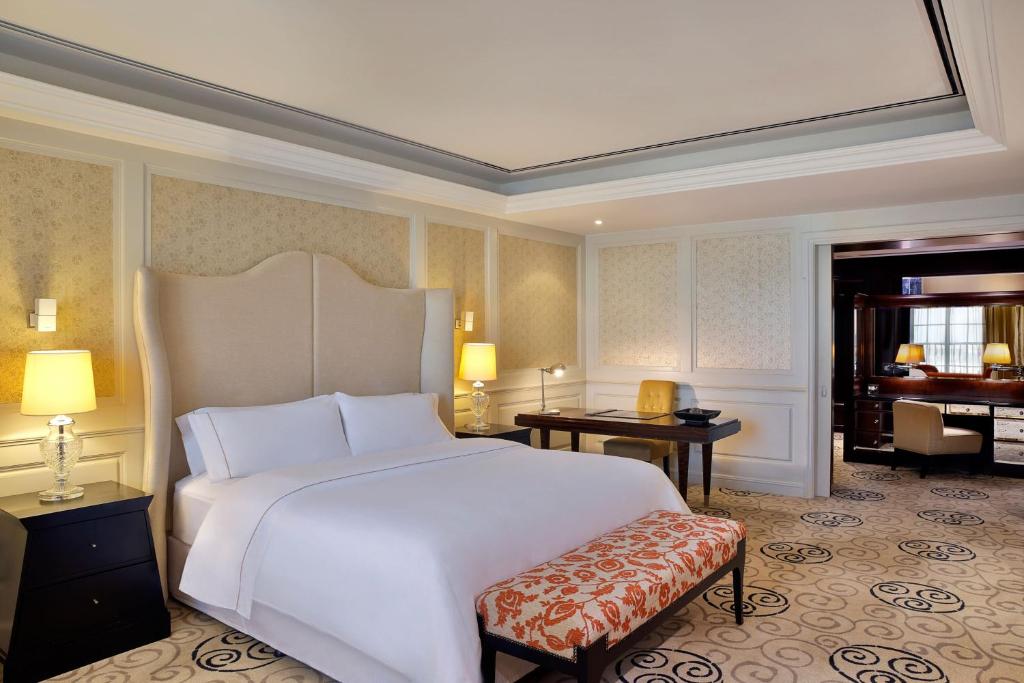 a bedroom with a large white bed and a piano at The Westin Dubai Mina Seyahi Beach Resort and Waterpark in Dubai