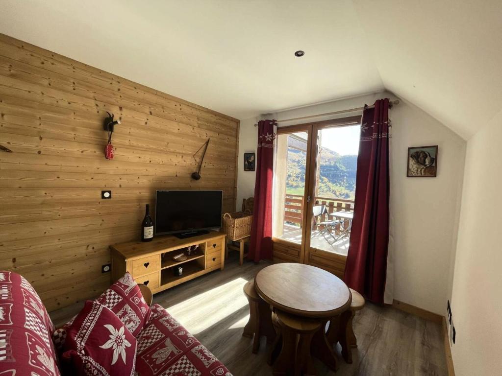 un salon avec une table et une télévision dans l'établissement Résidence Prince Des Ecrins - Appartement avec terrasse refait à neuf avec vue panoramique montagne MAE-5541, à Vénosc