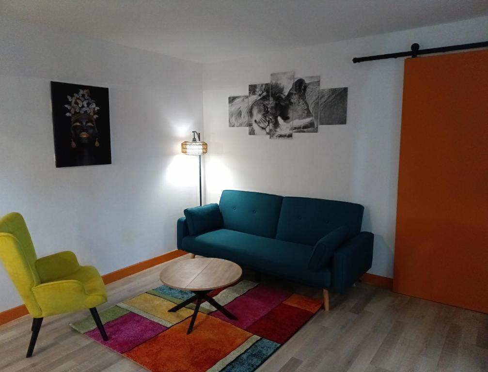 a living room with a blue couch and a table at Ma retraite spirituelle - curistes - à 2mn des Thermes et 45 mn de l'Espagne in Amélie-les-Bains-Palalda