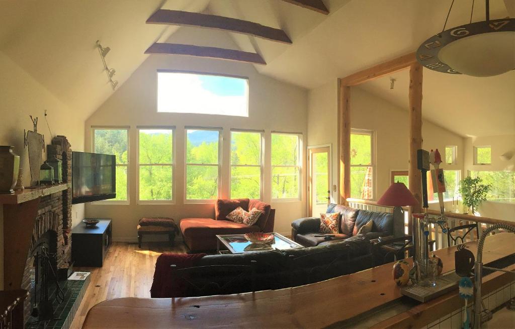 Una sala de estar con un sofá y un televisor. en Creekside Craftsman Cabin with Jacuzzi - Alpine Splendor 6 Mins to downtown, en Boulder