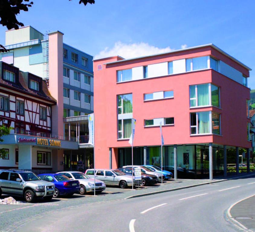 a street with cars parked in front of buildings at Hotel Sonne in Altstätten