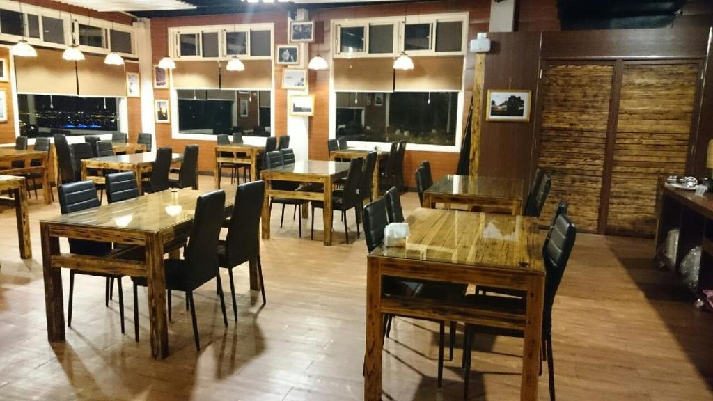 a dining room with wooden tables and chairs at Wan Ruey Resort in Hengshan