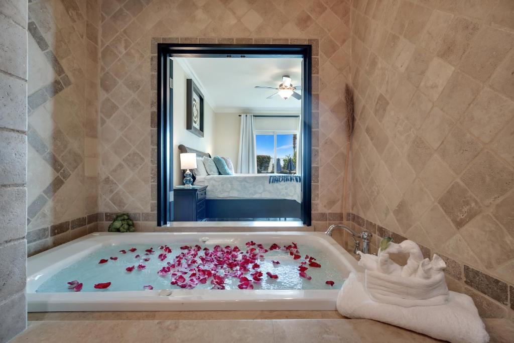 a bathroom with a bath tub filled with flowers at Casa Sirena Cabo Poolside Oasis Minutes from Beach in Cabo San Lucas