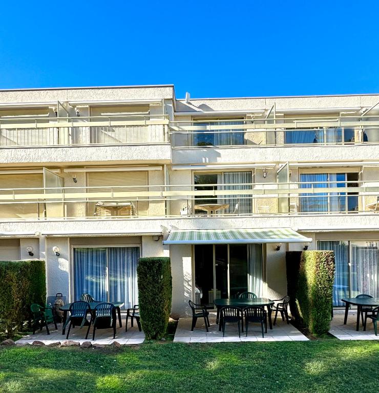 un bâtiment avec des tables et des chaises devant lui dans l'établissement Rez-jardin rénové à Saint-Raphaël, Côte d'Azur, à Saint-Raphaël