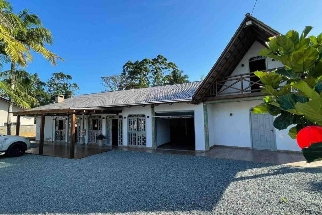 サン・フランシスコ・ド・スルにあるChácara Rota das Praias - Ubatuba - São Francisco do Sulの前に車が駐車されている家