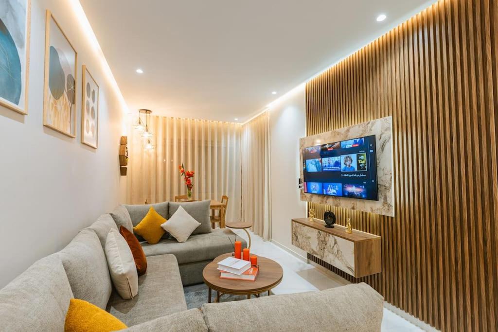 a living room with a couch and a tv at Charmant Appartement à Marina in Tangier