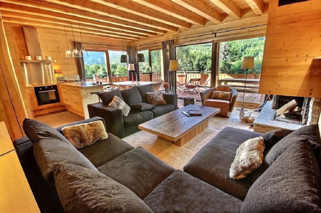 a living room with a couch and a fireplace at Chalet Prestige cheminée vue excep serrechevalierholidays in Le Freyssinet