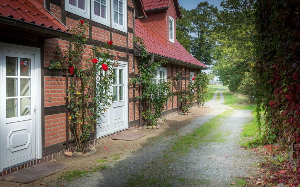 ein Haus mit weißen Türen und Rosen an der Seite in der Unterkunft Landhaus Elbeflair bei Dömitz in Lenzerwische