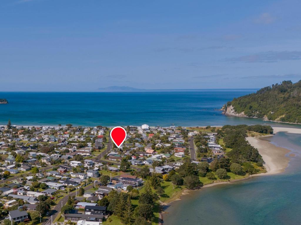 a red balloon is flying over a beach at Whanga Bach - Whangamata Holiday Home in Whangamata