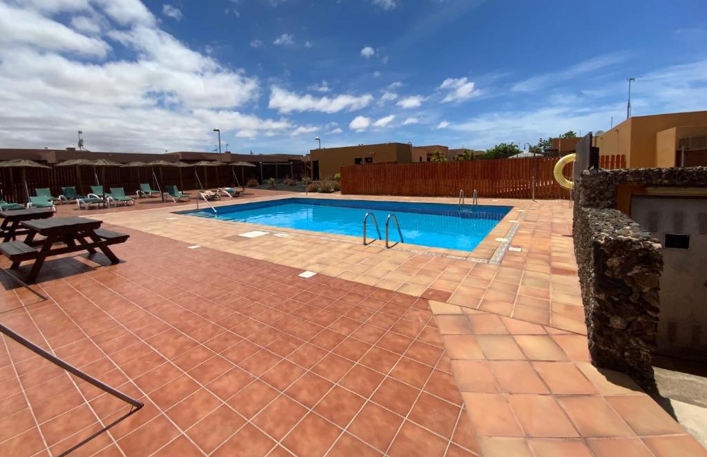 a swimming pool with a picnic table and a bench at Villa Bejeque & Barbecue in La Oliva