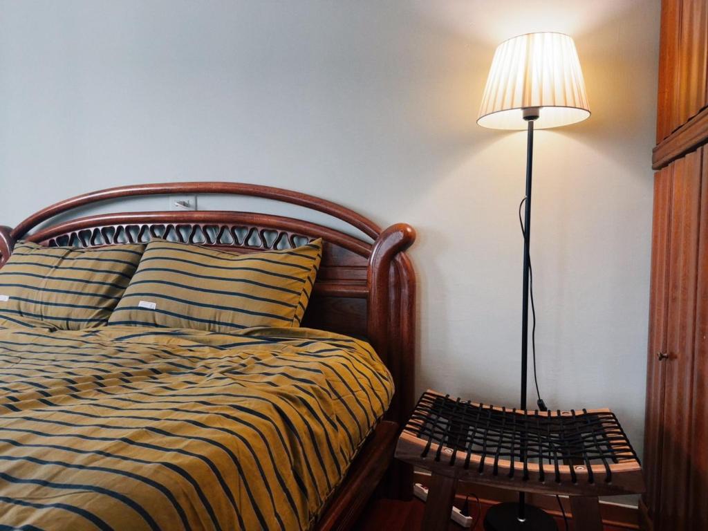 a bedroom with a bed and a lamp on a table at Sunday Inn in Tainan