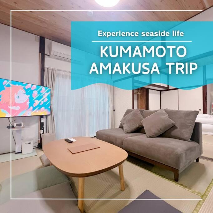 a living room with a couch and a table at 夕日と海の貸切宿 海しずく in Kami Amakusa