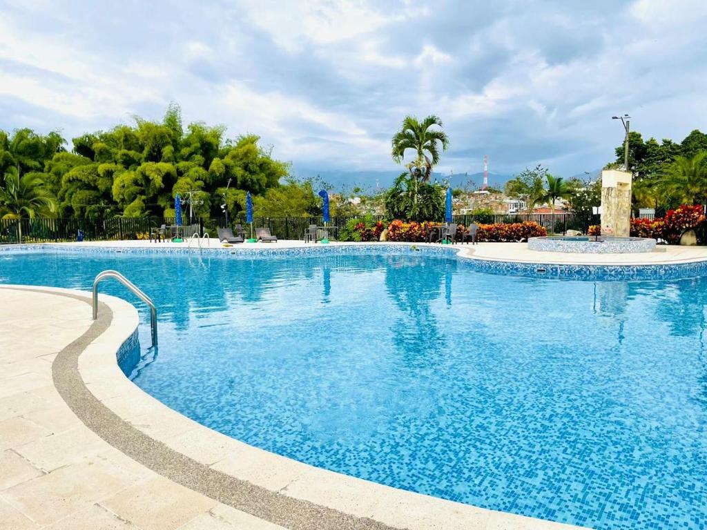 a large swimming pool with blue water in a resort at Vacaciones Eje Cafetero Parque del Cafe WIFI 114C in La Tebaida