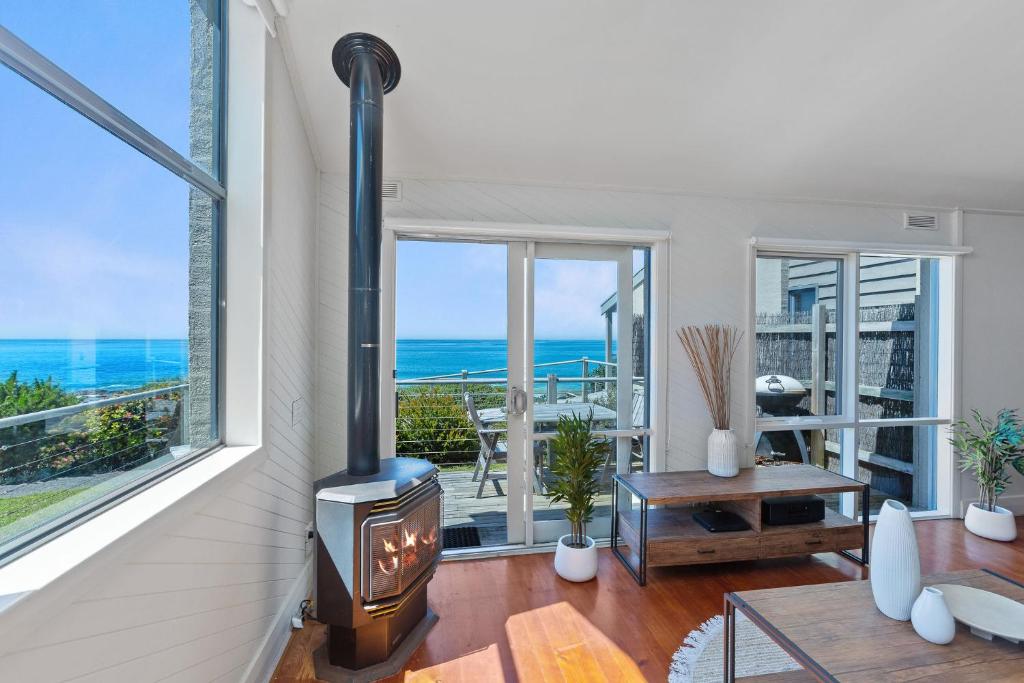 a living room with a fireplace and a view of the ocean at 3 Whitecrest Great Ocean Road Resort - Ocean Views in Wongarra