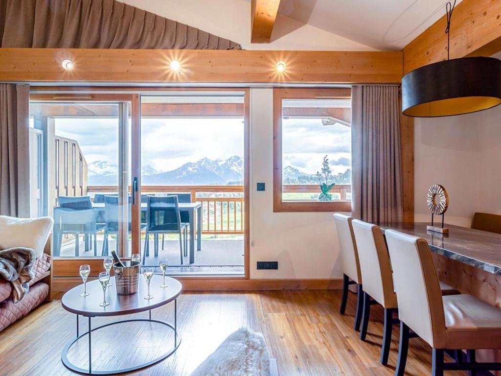 une cuisine et un salon avec une table et des chaises dans l'établissement Appartement haut de gamme 10 pers, Spa & parking, Les Saisies - FR-1-810-2, aux Saisies