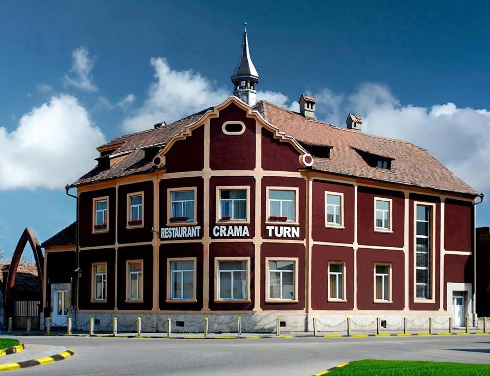 a large wooden building with a tower on top of it at Cazare Turn Sebes in Sebeş