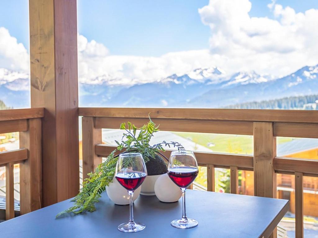 - deux verres de vin assis sur une table sur un balcon dans l'établissement Appartement 4 pièces avec SPA et parking - Les Saisies - FR-1-810-11, aux Saisies