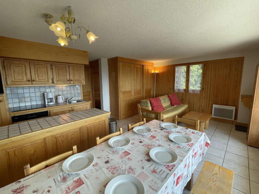 une cuisine avec une table avec des assiettes dessus dans l'établissement Appartement 3 pièces, Les Saisies, ski-in, 9 pers, balcon sud - FR-1-810-18, aux Saisies