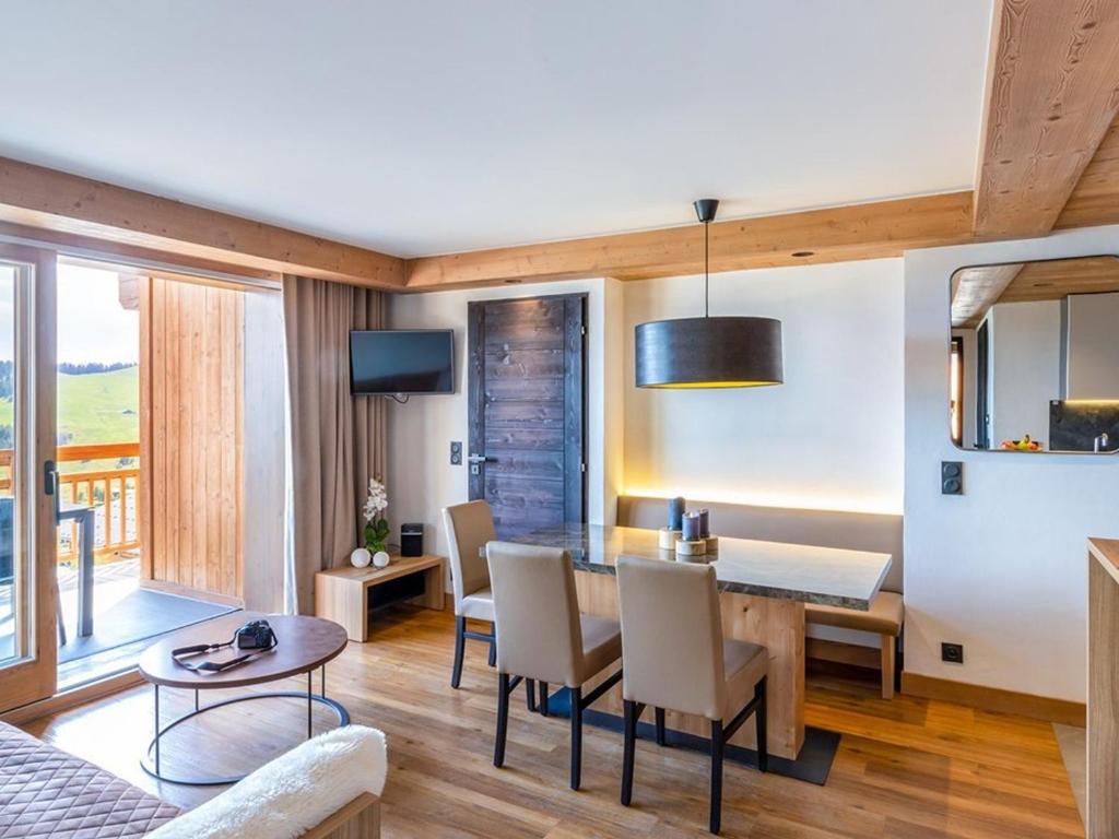 a dining room and living room with a table and chairs at Appartement de standing 4 pièces, SPA, parking, Les Saisies - FR-1-810-10 in Les Saisies