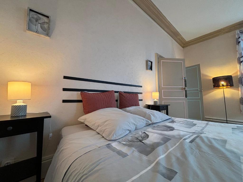 une chambre avec un grand lit blanc avec deux lampes dans l'établissement Chambres élégantes avec piscine et parking - FR-1-591-696, à Le Blanc