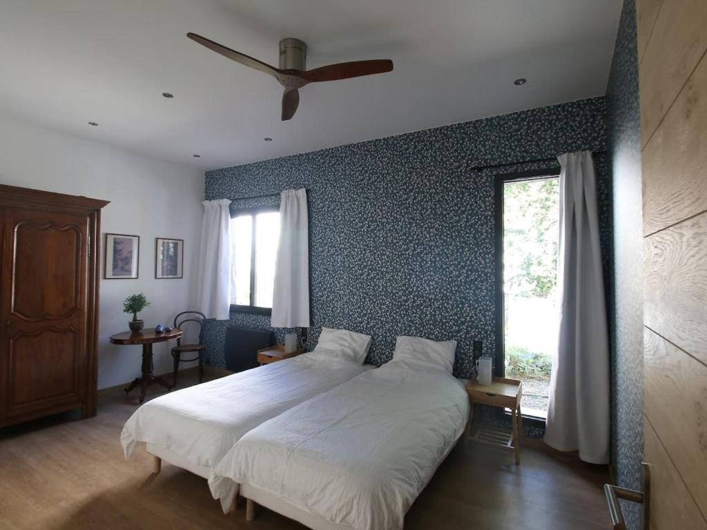 a bedroom with a large bed and a window at Chambre "Madeleine" avec 2 lits simples et table d'hôtes - FR-1-590-468 in La Ferté-Saint-Aubin