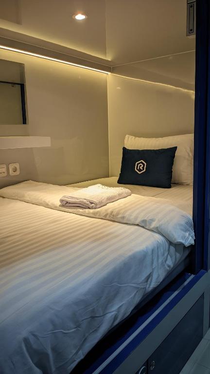 Postel nebo postele na pokoji v ubytování Rosalyne Sleepbox Tugu Kranggan