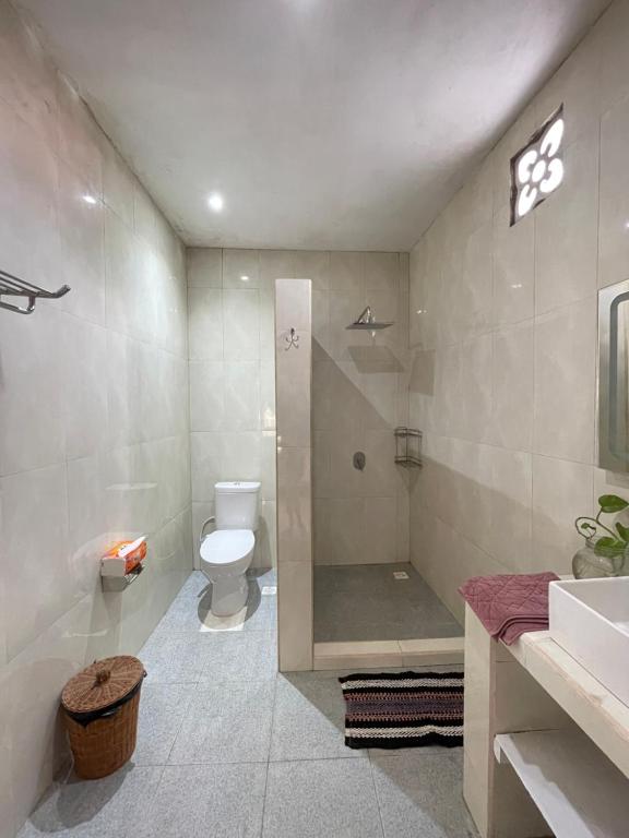 a bathroom with a shower and a toilet and a sink at Woody House in Bedugul