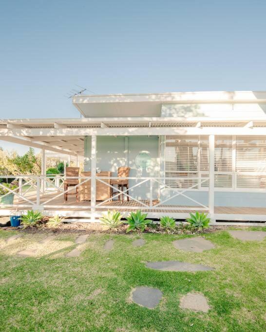 a house with a screened in porch with a lawn at Shellwater at Sellicks Beach Large Double Block Coastal Family Getaway in Sellicks Beach