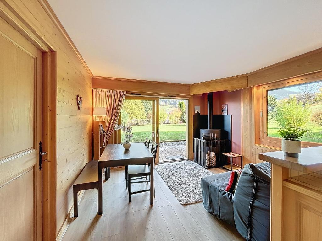 un salon avec une table et un canapé dans l'établissement Confortable 2 pièces avec jardin, parking, face au Mont Blanc - FR-1-560-152, à Combloux