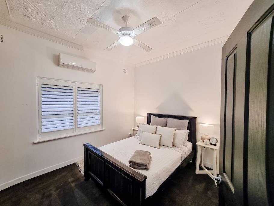 a bedroom with a bed with a ceiling fan at Peters Rest Central Wagga in Wagga Wagga