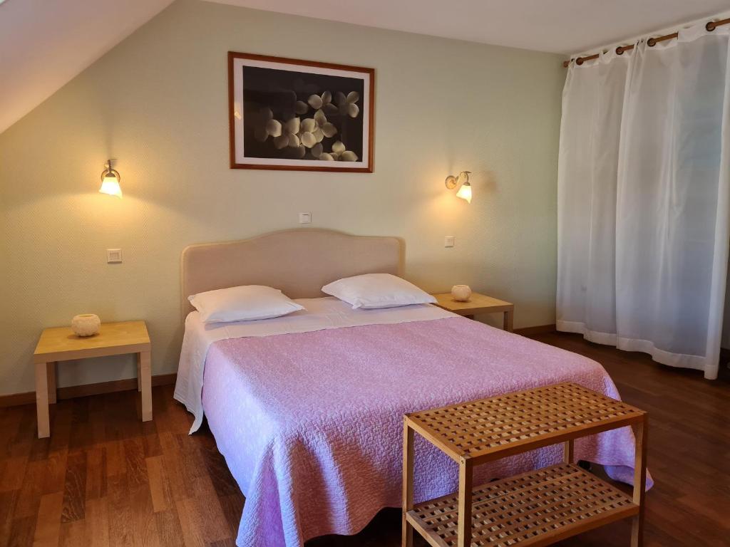 una camera da letto con un letto con copriletto viola di Ferme rénovée au calme - 4 chambres, petit-déjeuner inclu - FR-1-590-450 a Cravant