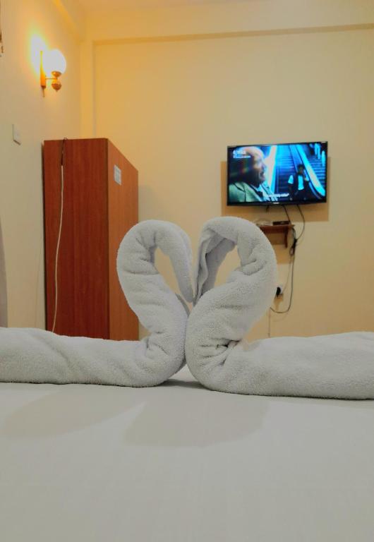 a pair of swans made out of towels on a bed at Madara Hotel in Horana
