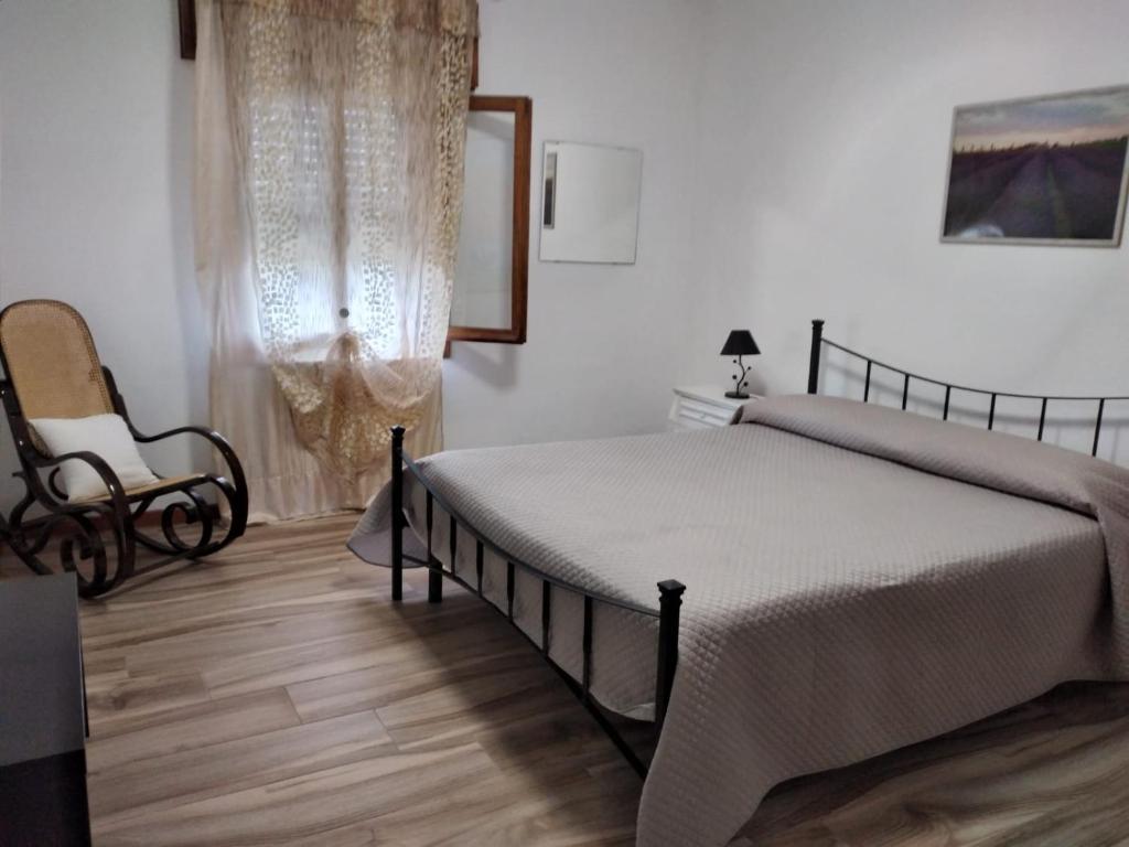 una camera da letto con un letto e una sedia di Locazione Turistica Girasole a Porto Tolle
