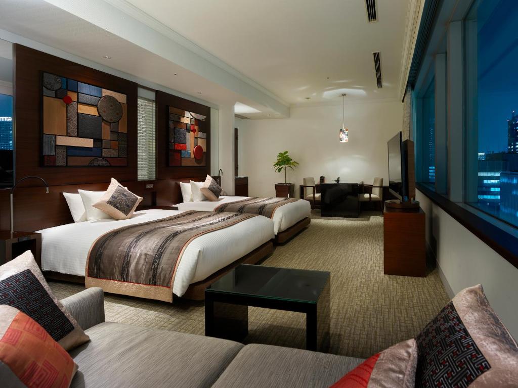 a hotel room with two beds and a couch at Hotel The Celestine Tokyo Shiba in Tokyo