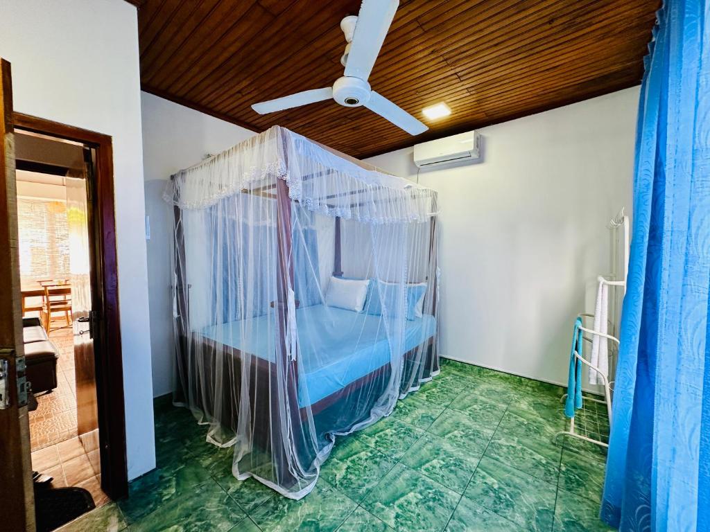 ゴールにあるTraveller's Lodge Unawatunaのベッドルーム1室(天蓋付きベッド1台付)