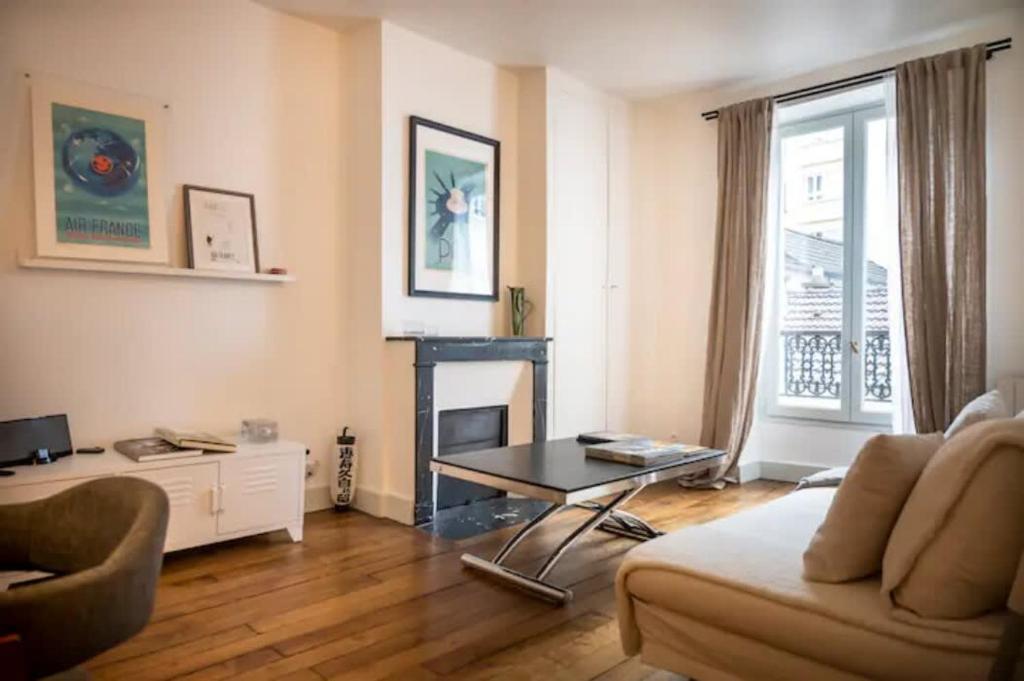 un salon avec un canapé et une cheminée dans l'établissement Villa Montparnasse - 15th arr, à Paris