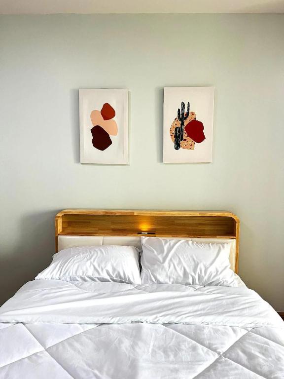 a bedroom with two pictures on the wall and a bed at Tranquil Urban Retreat at Cheangwattana in Pak Kret