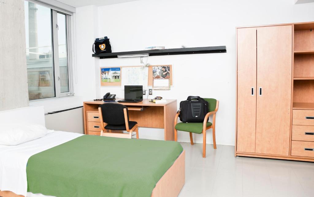 - une chambre avec un lit et un bureau avec un ordinateur dans l'établissement University of Toronto-New College Residence-45 Willcocks Residence, à Toronto