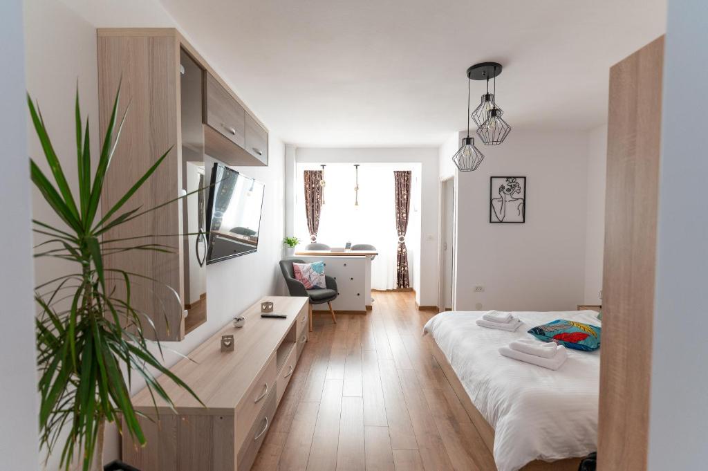 ein Schlafzimmer mit einem Bett und einer Topfpflanze in der Unterkunft Ten House in Piteşti