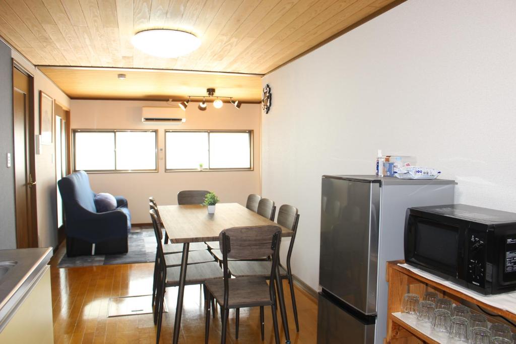 a kitchen and dining room with a table and a refrigerator at Hotel Relation in 門司港 in Kitakyushu
